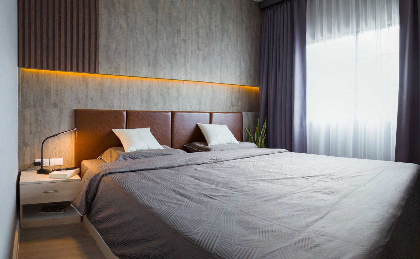 A bedroom with a full-height window, the Deluxe apartment